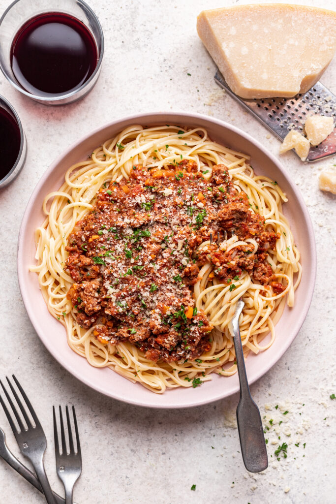 pasta with bolognese sauce on a pink plate