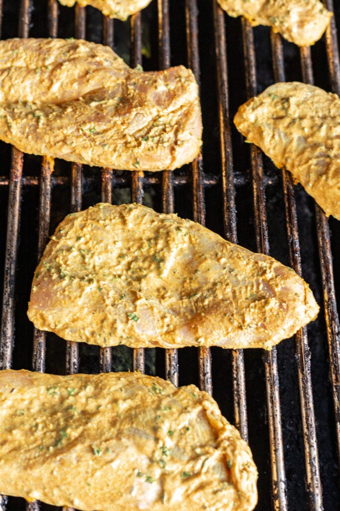 raw yogurt marinated chicken on a grill