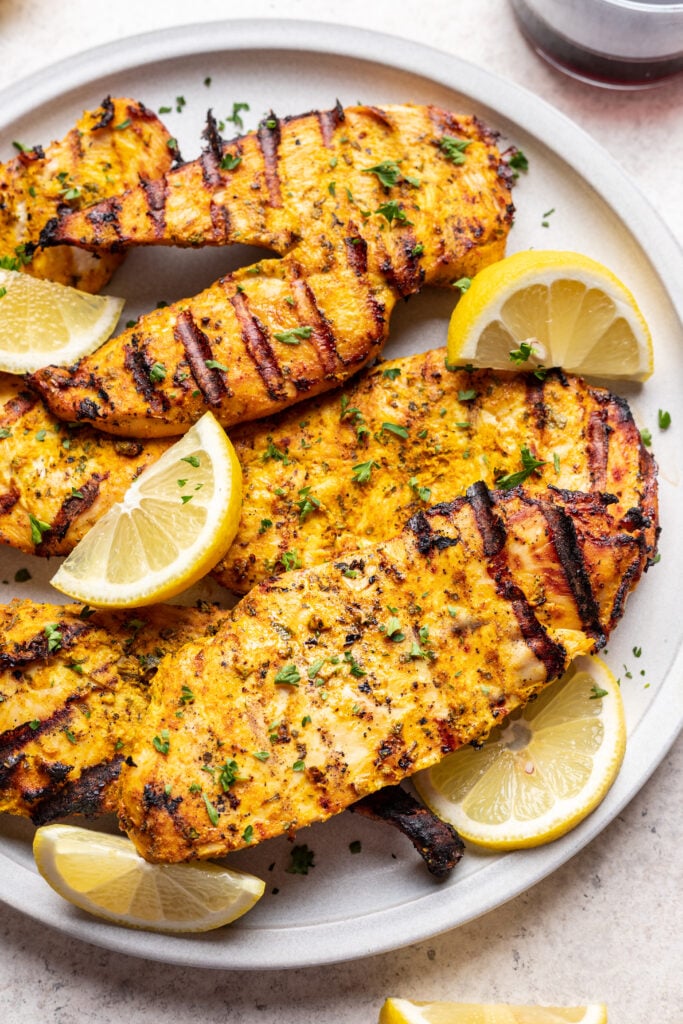 grilled chicken on a plate with lemon slices