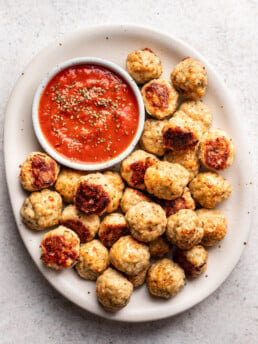 chicken meatballs on a white platter with marinara dipping sauce