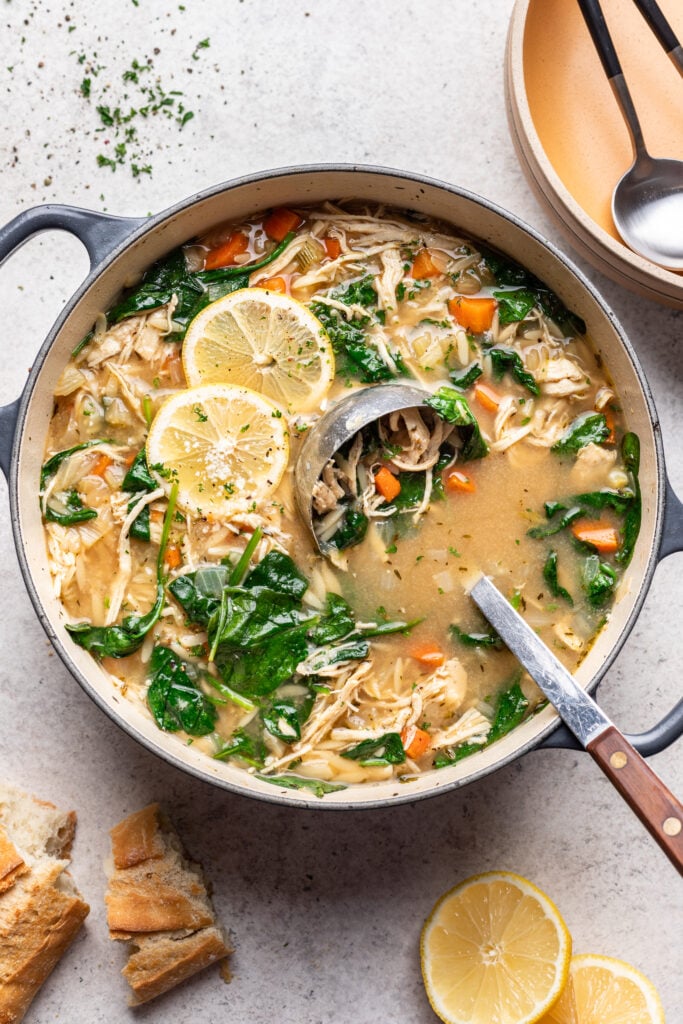 large pot of chicken lemon orzo soup with a ladle