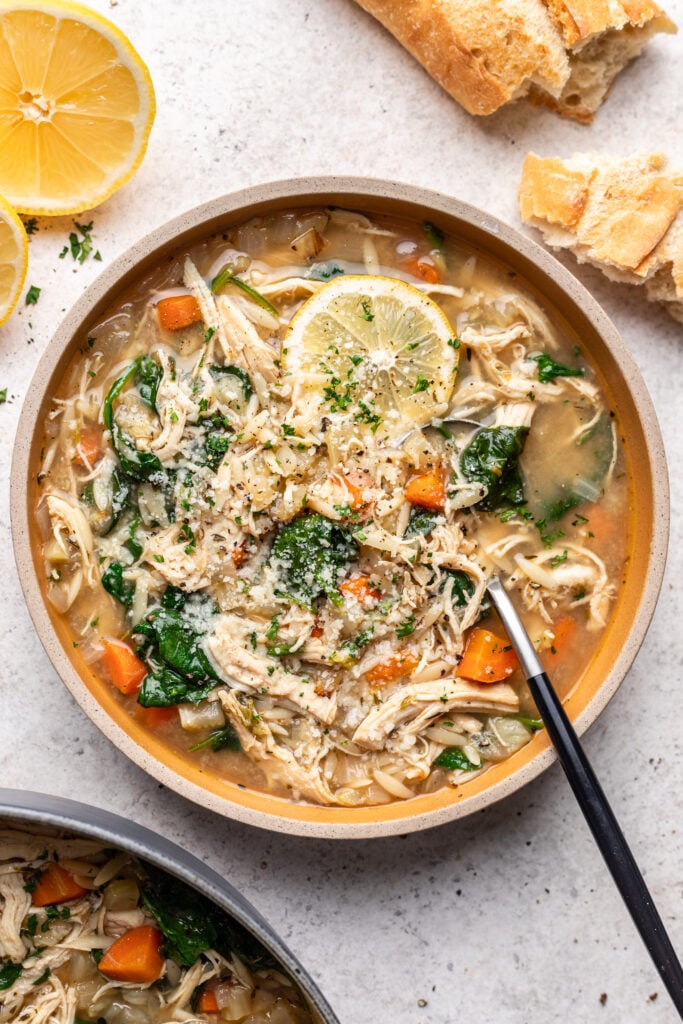 bowl of chicken lemon orzo soup with a spoon