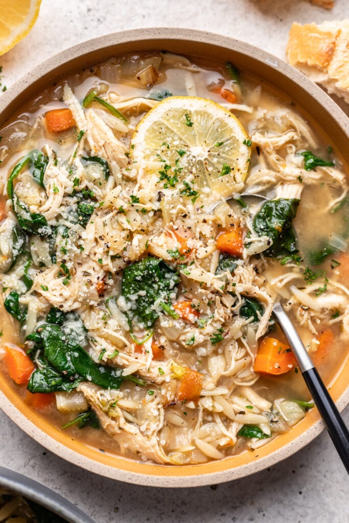 bowl of chicken lemon orzo soup with a spoon