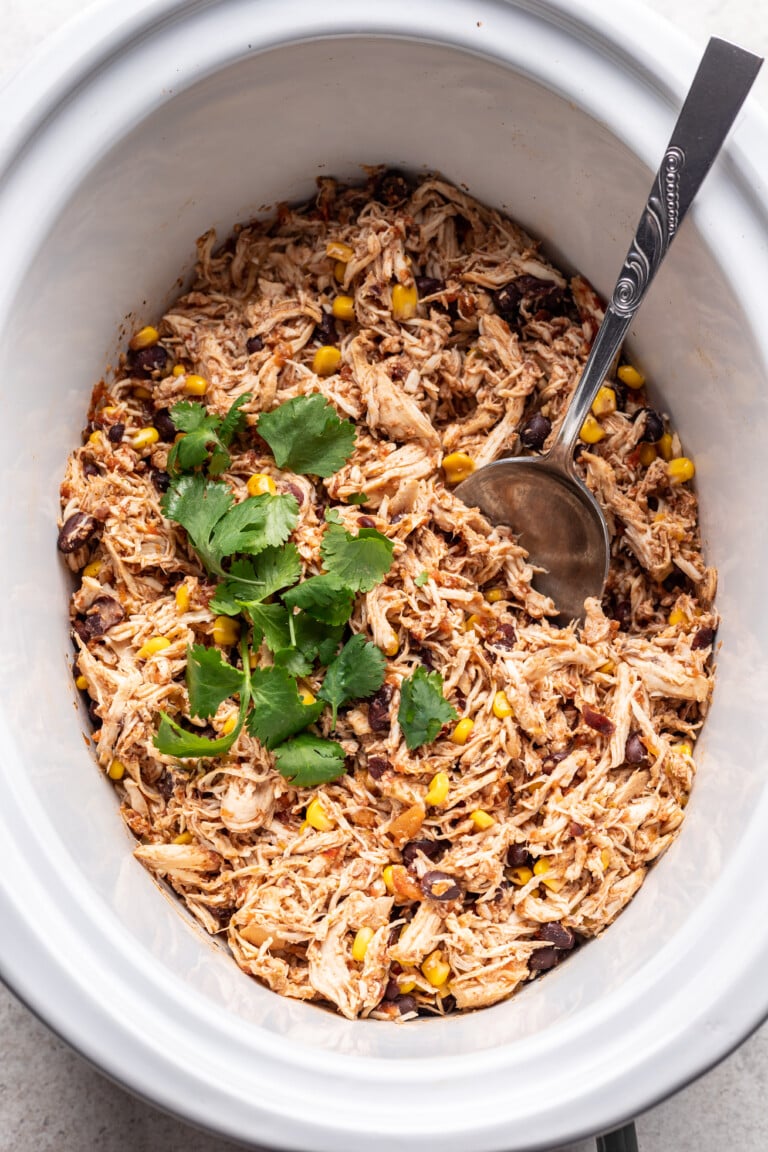 shredded mexican chicken with a spoon in a slow cooker