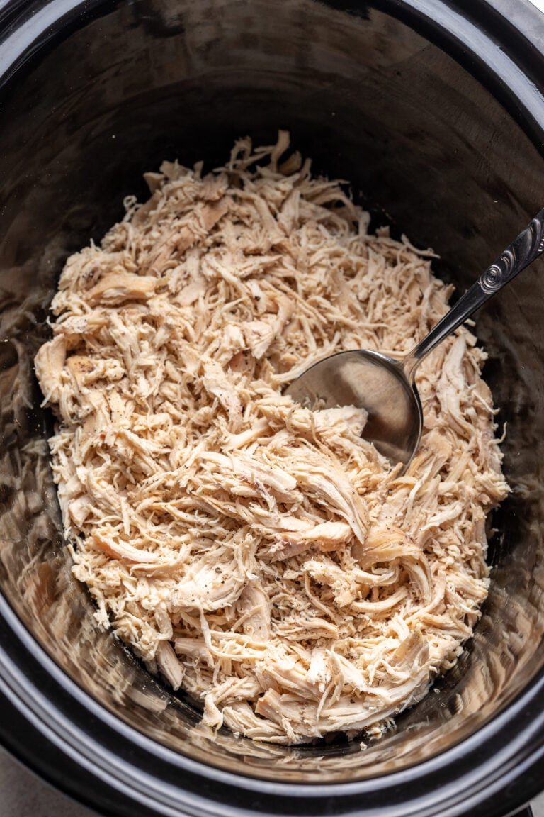 shredded chicken with a spoon sticking in a slow cooker