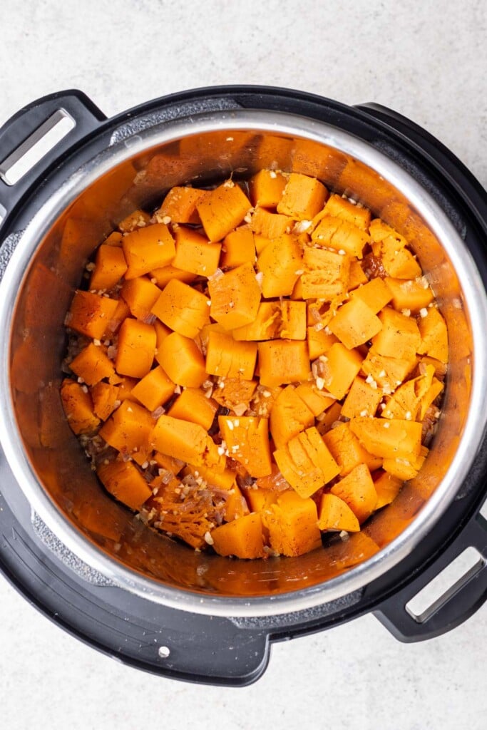 cubed butternut squash in an instant pot with spices