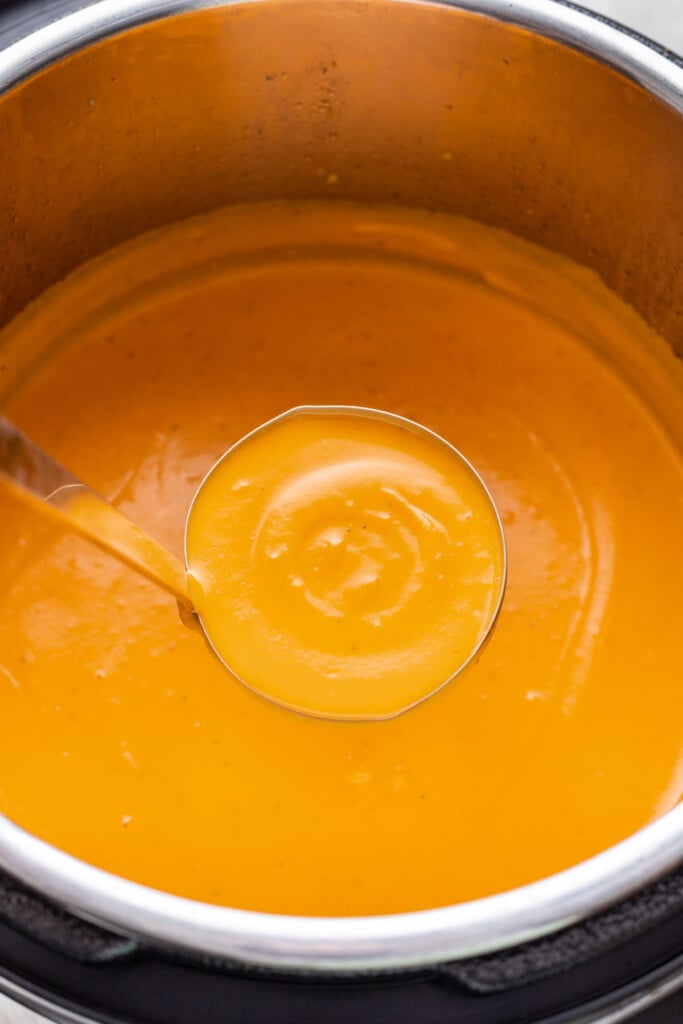 blended butternut squash soup in an instant pot with a ladle