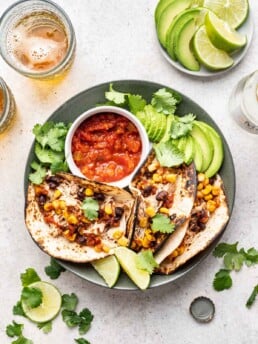 shredded chicken tacos on a plate with salsa and avocado