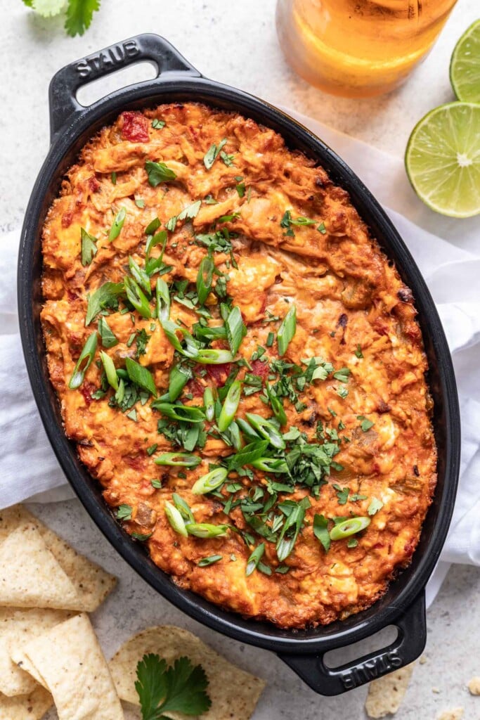 baked shredded chicken dip in baking dish topped with scallions
