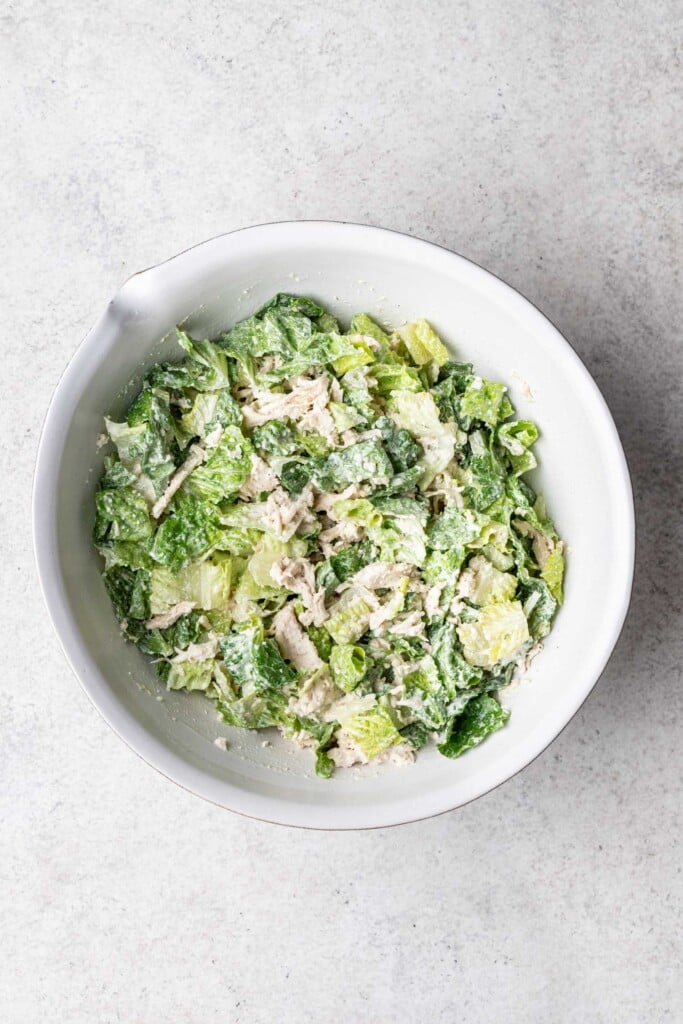 caesar salad with shredded chicken in a bowl