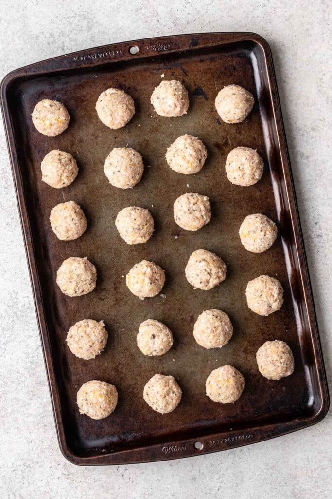 raw chicken meatballs on a sheet pan