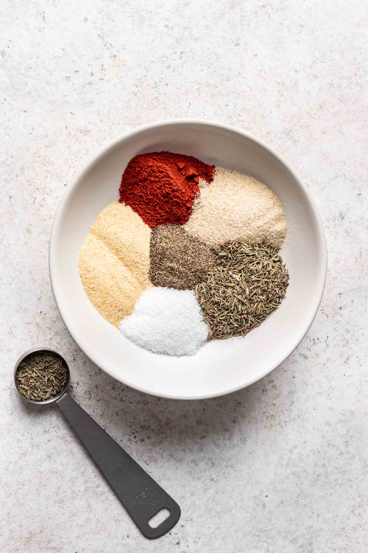 one white bowl with 6 different spices