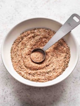 a bowl with spices and a measuring spoon