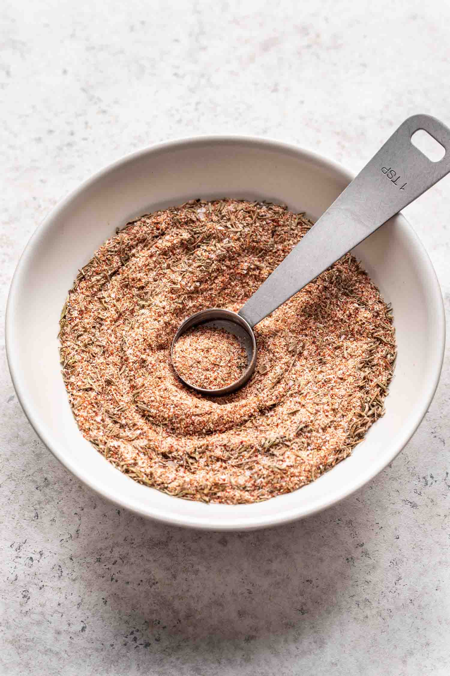 a bowl with spices and a measuring spoon