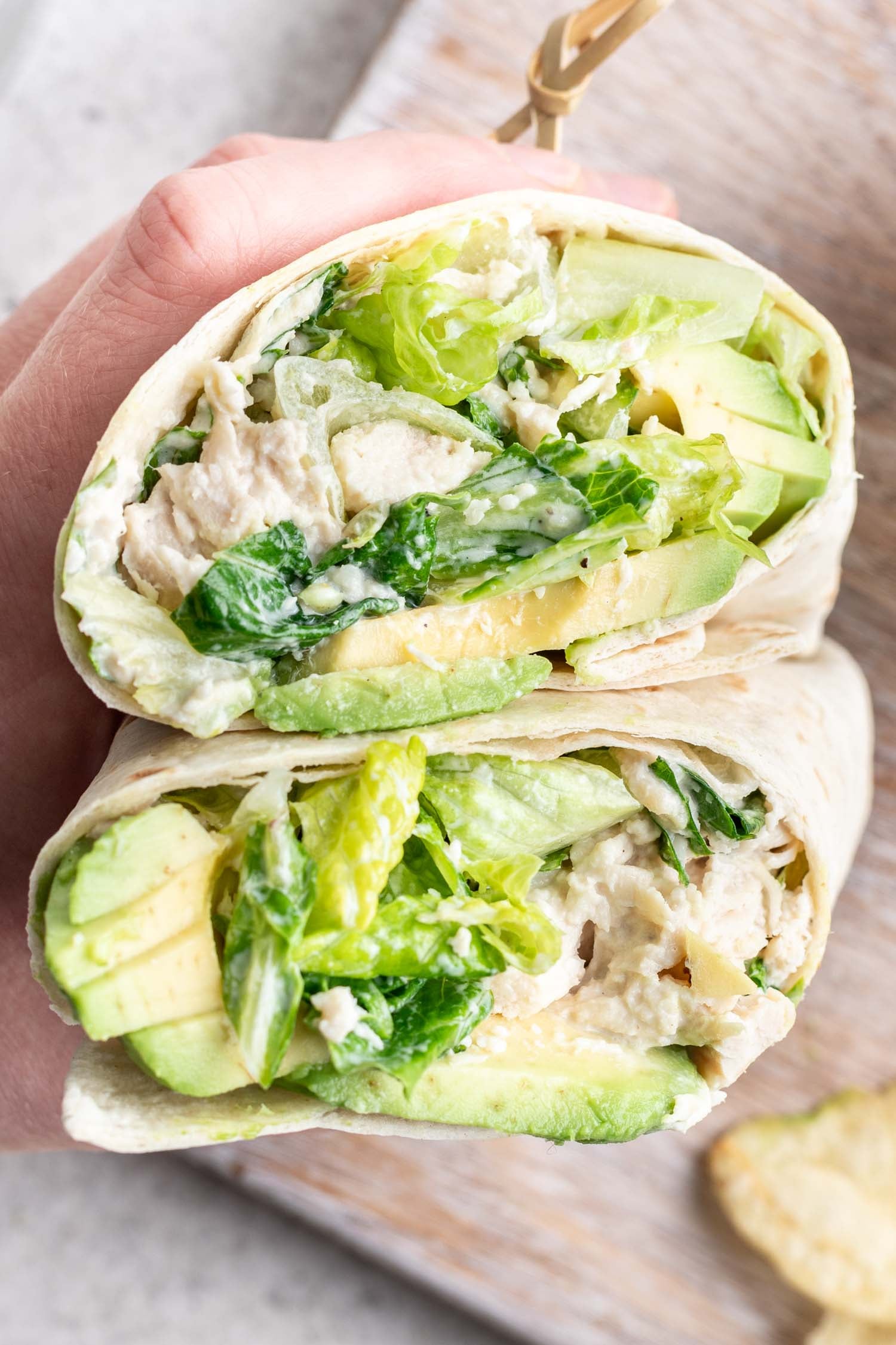 a wrap stacked and cut in half being held by a hand