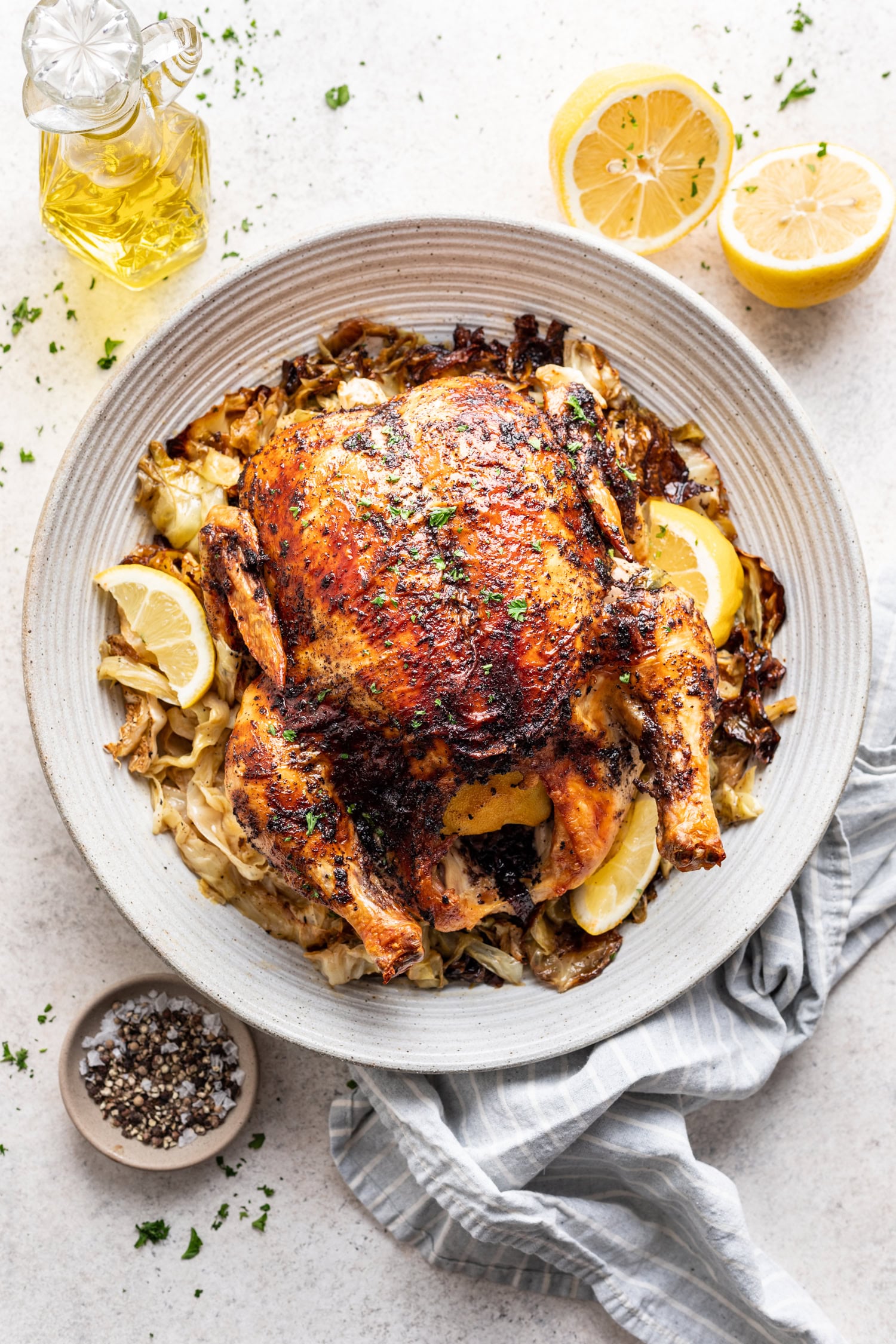Sumac Roast Chicken on a white platter with cabbage and lemon