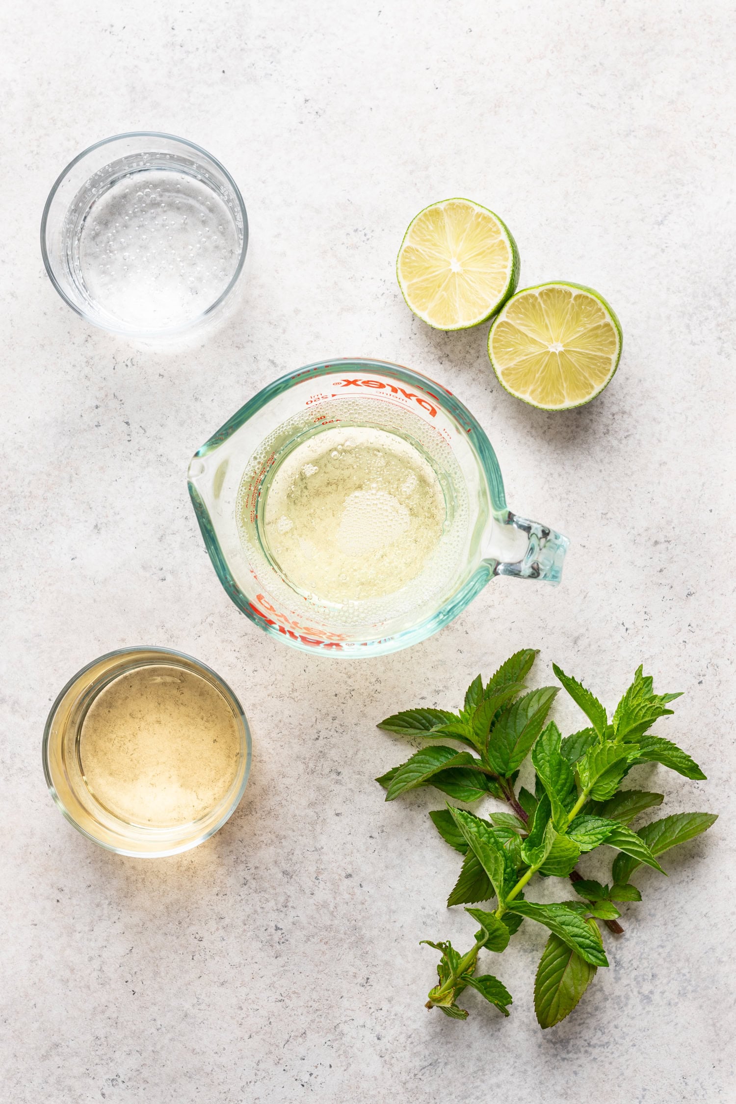 cocktail ingredients on a board. lime, mint, sparkling water, prosecco