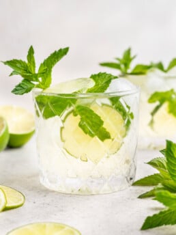 hugo spritz cocktail in a glass with ice, lime and mint