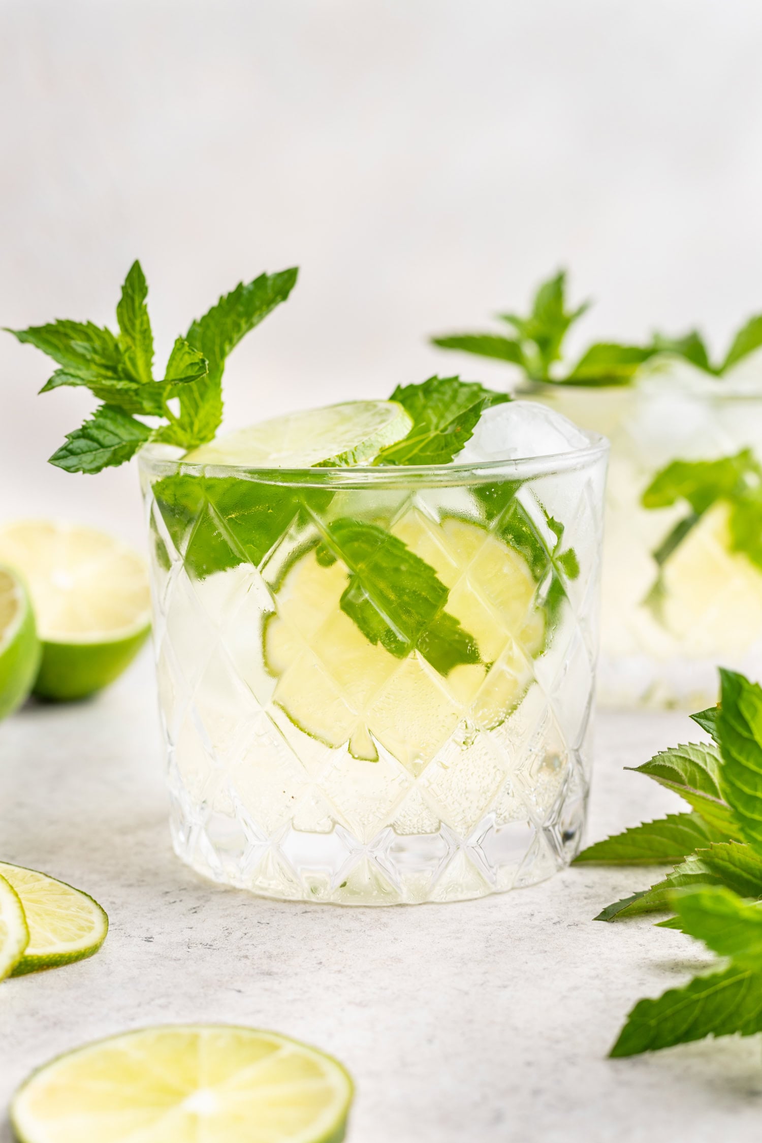 hugo spritz cocktail in a glass with ice, lime and mint