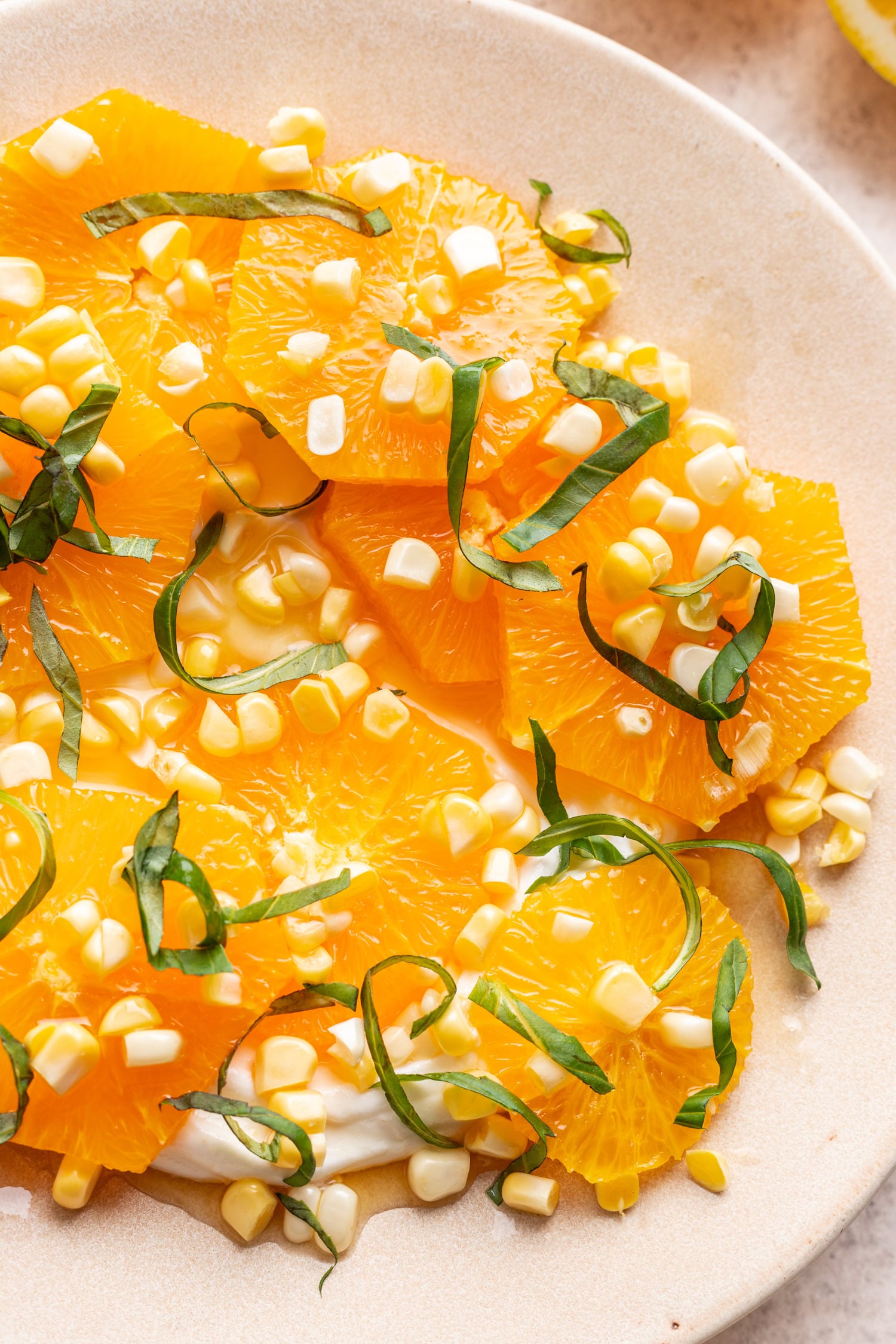 close up of sliced oranges, raw corn and basil