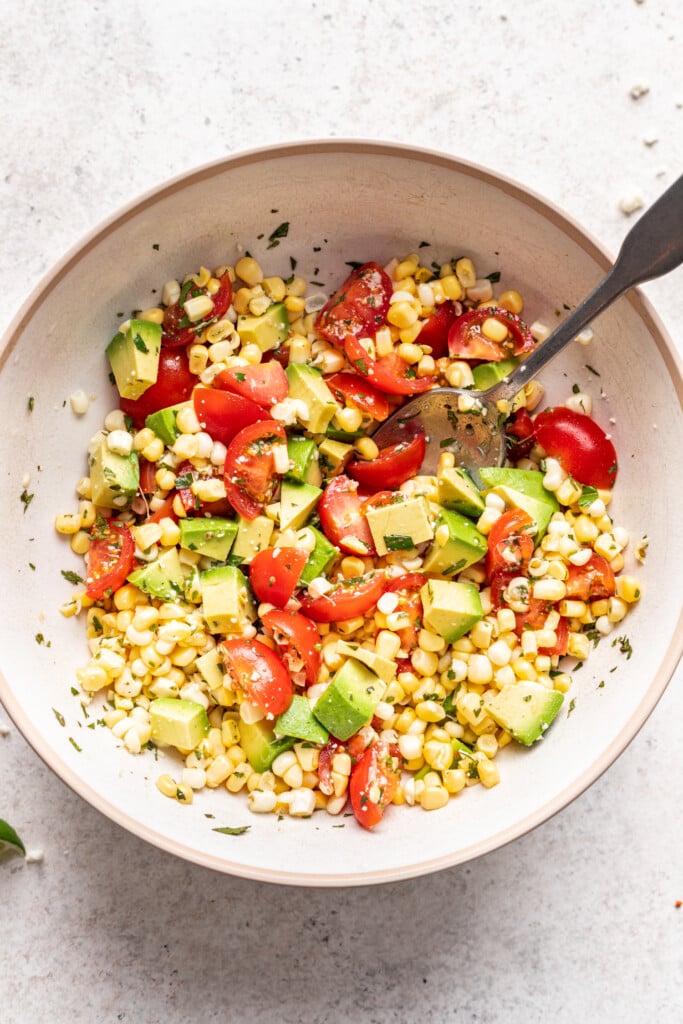 bowl of fresh corn salsa with a spoon