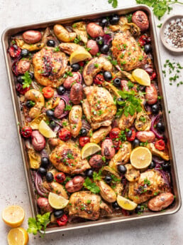 Chicken thighs on a sheet pan with roasted potatoes, olives and tomatoes