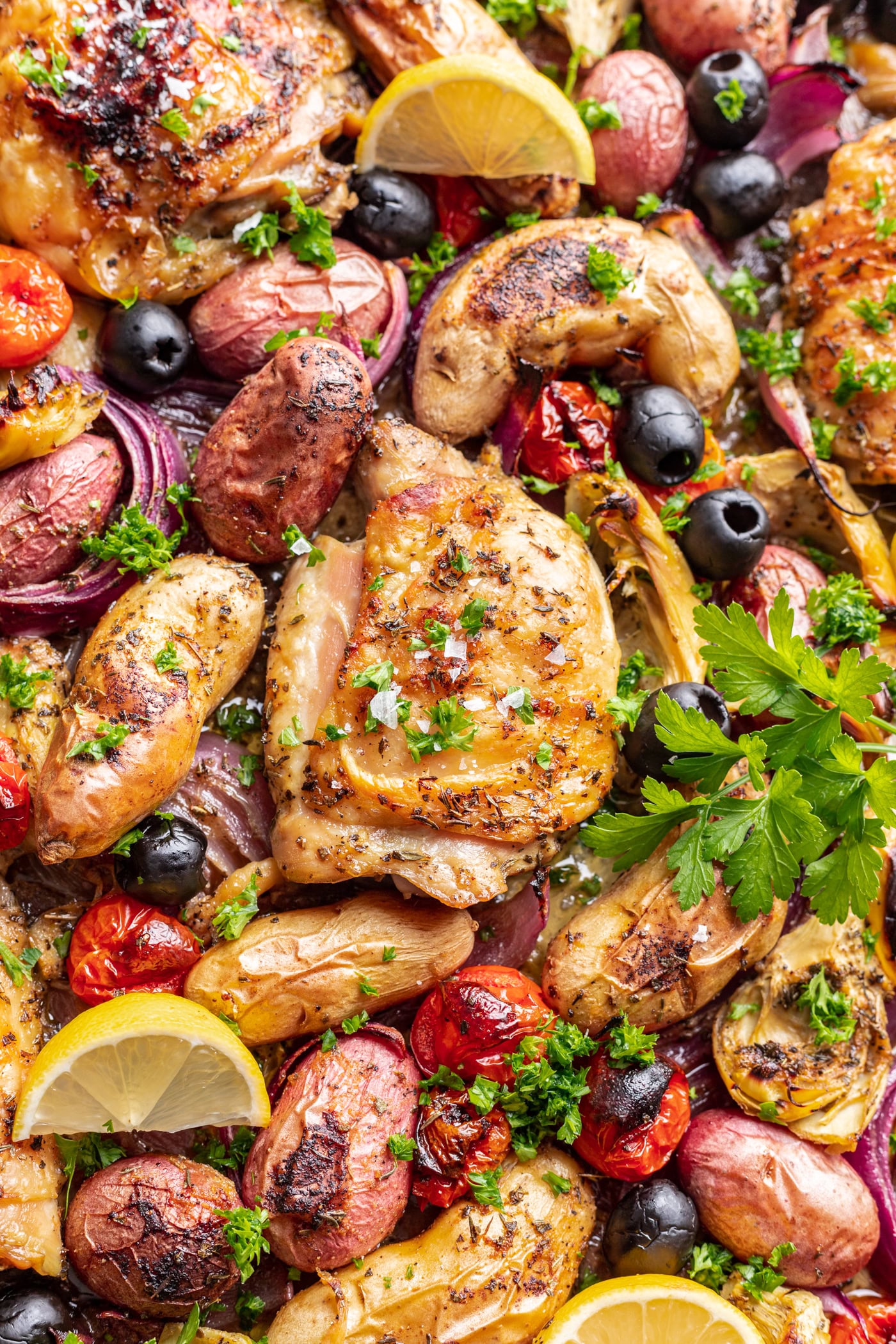 roasted chicken thigh with potatoes, olives and tomatoes