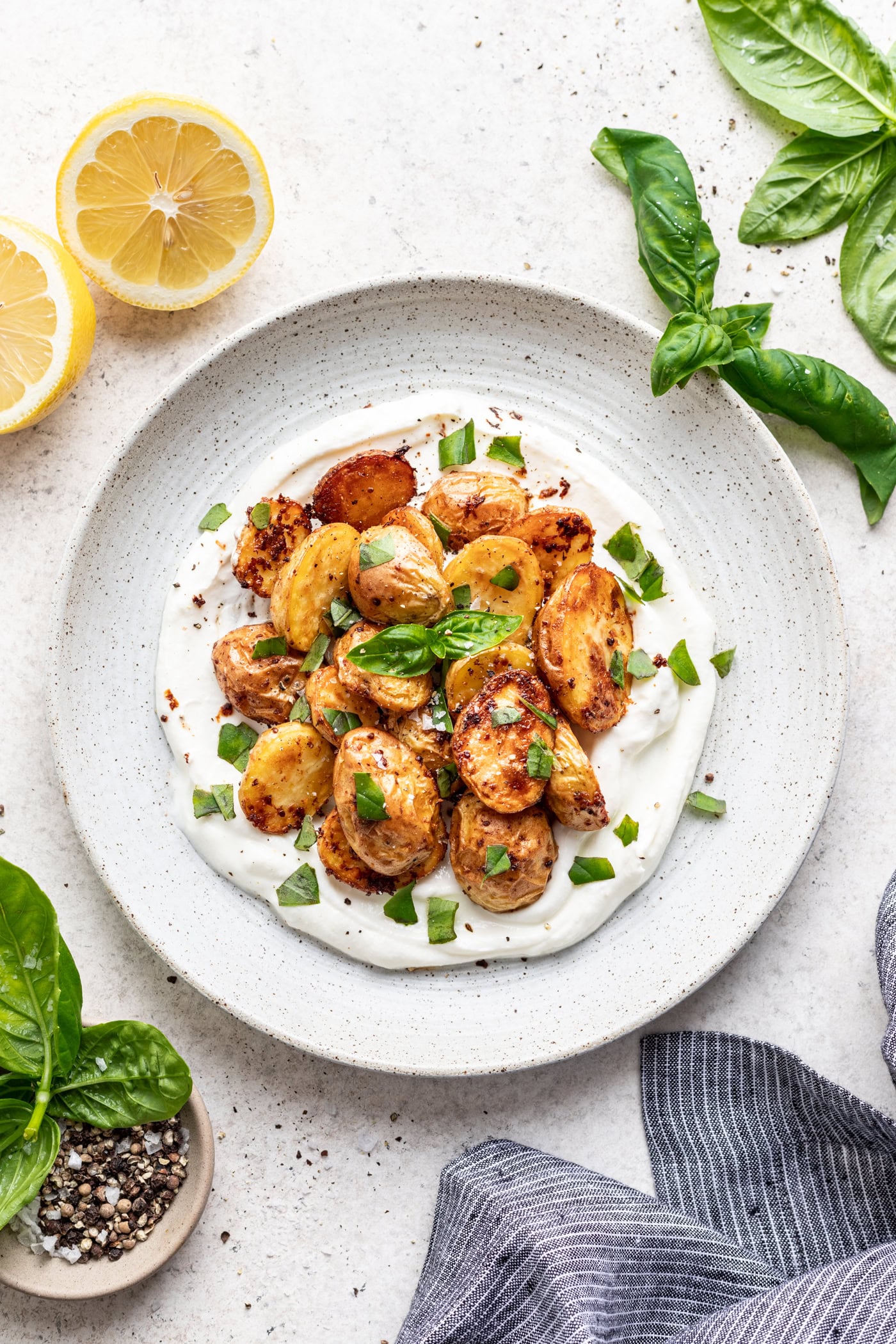 white plate with roasted potatoes on a bed of greek yogurt