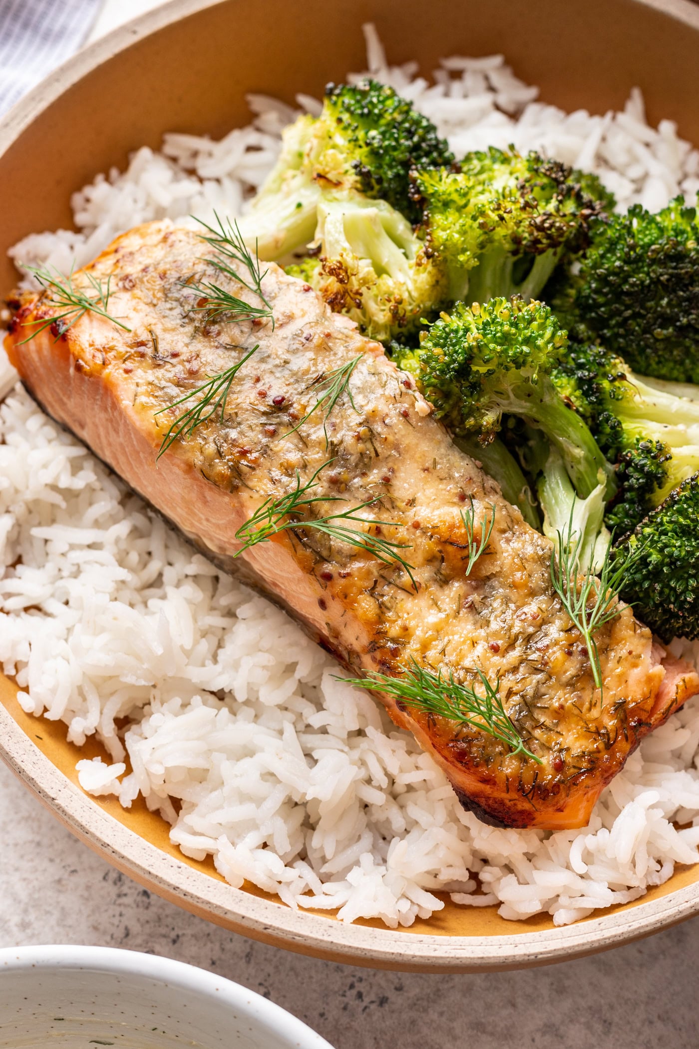 salmon with dill sauce served over broccoli and rice