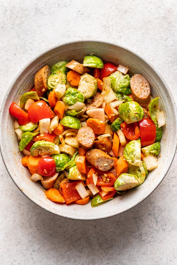 bowl with raw veggies and chicken sausage