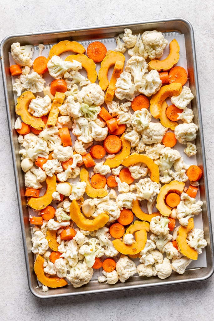 diced carrots, cauliflower and delicata squash on a sheet pan