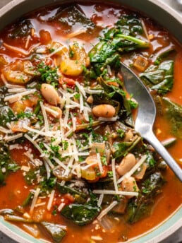 a bowl of spinach and white bean soup with a spoon