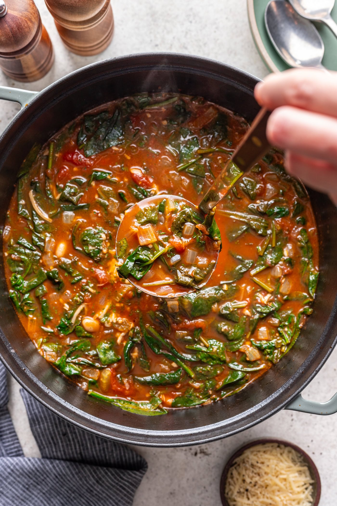 big pot of spinach and white bean soup with a ladle