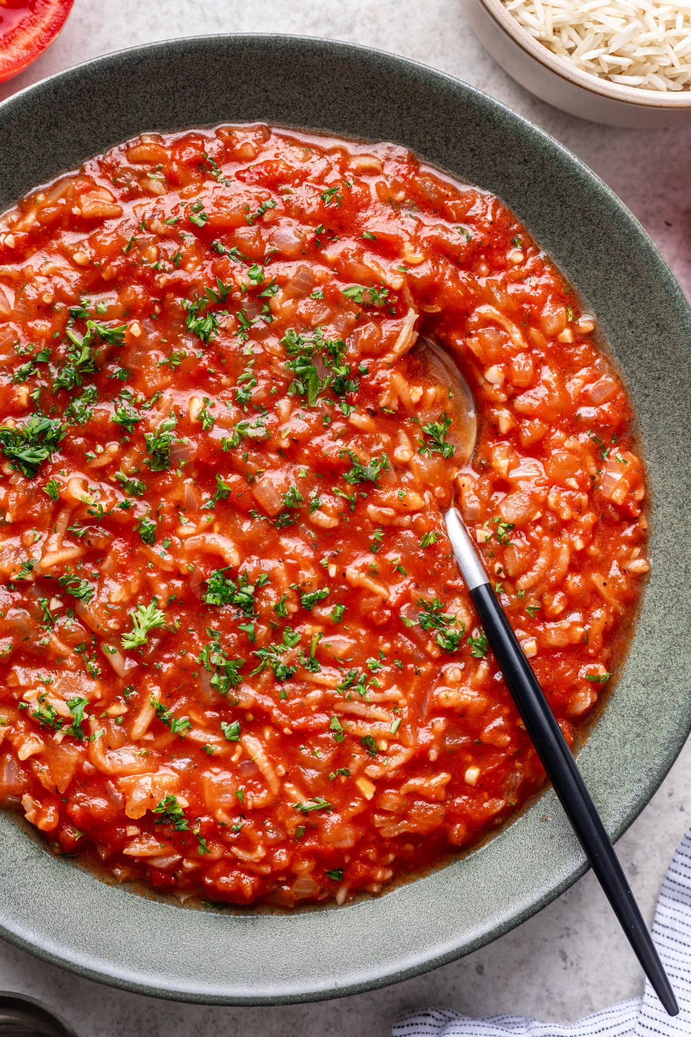 a bowl of tomato rice soup with a spoon