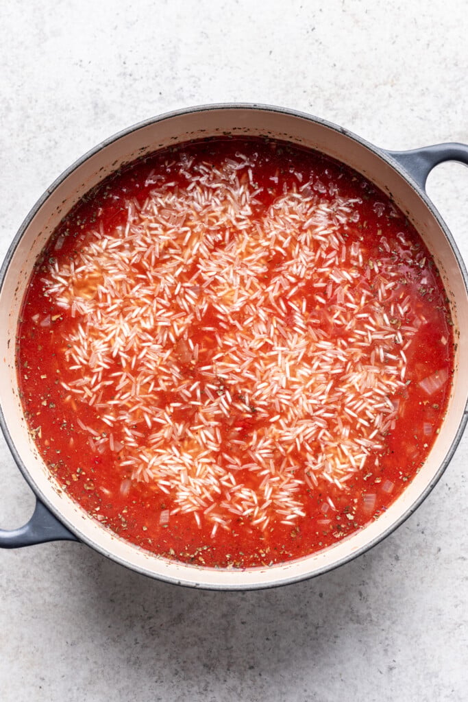 crushed tomatoes, rice and spices in a pot