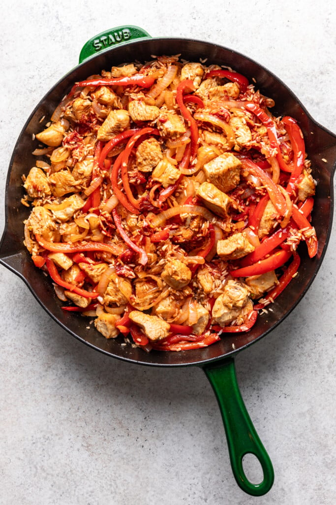 chicken, rice, peppers and onions in a pans