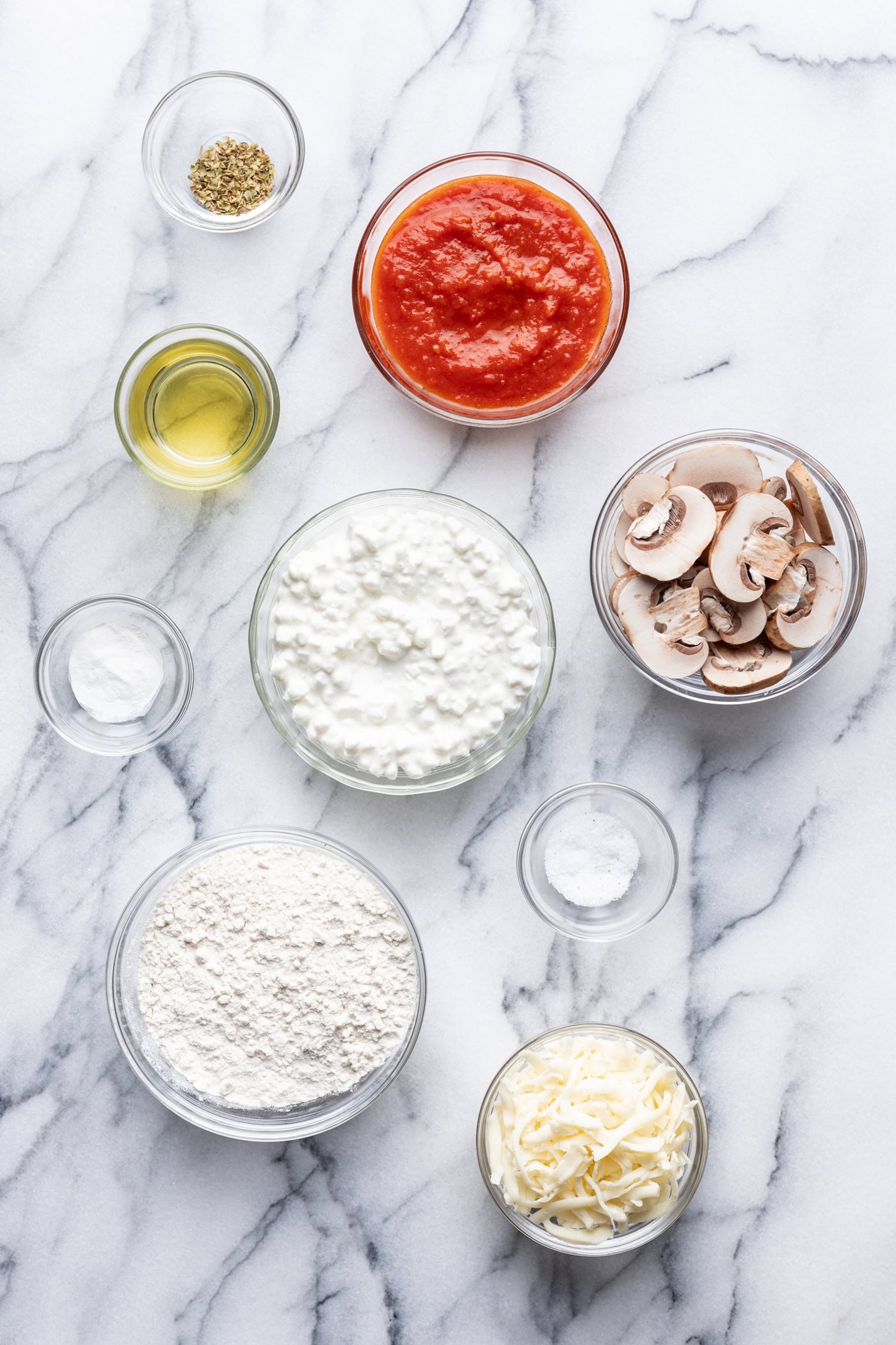 Ingredients for pizza dough on a marble counter