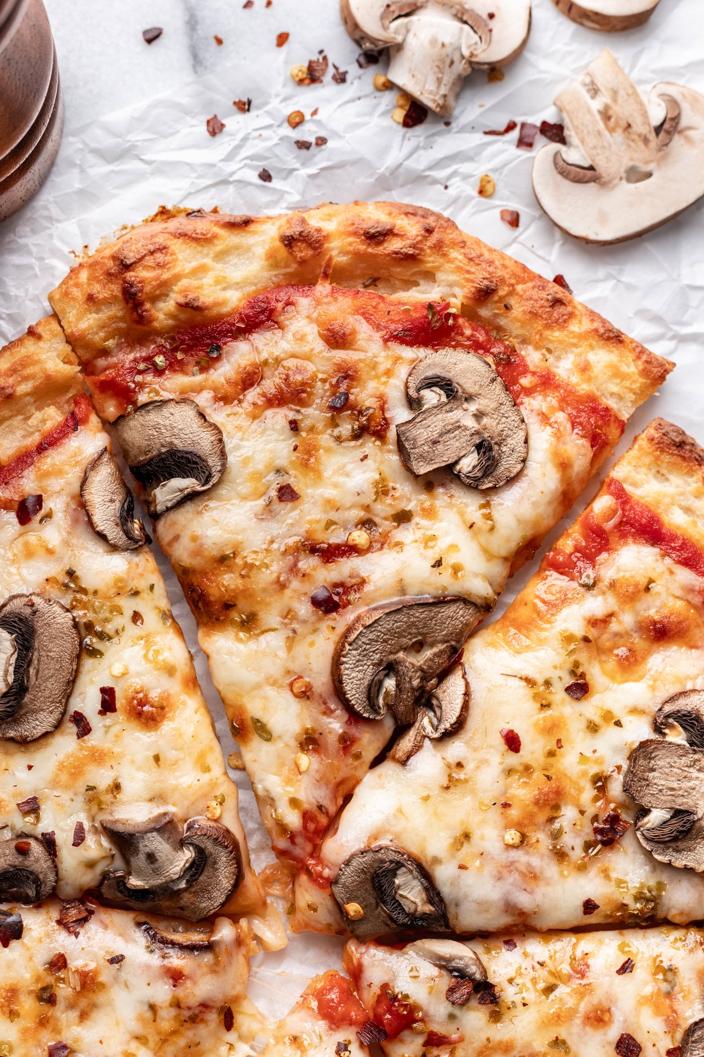 A pizza slice with mushrooms and cheese on a table