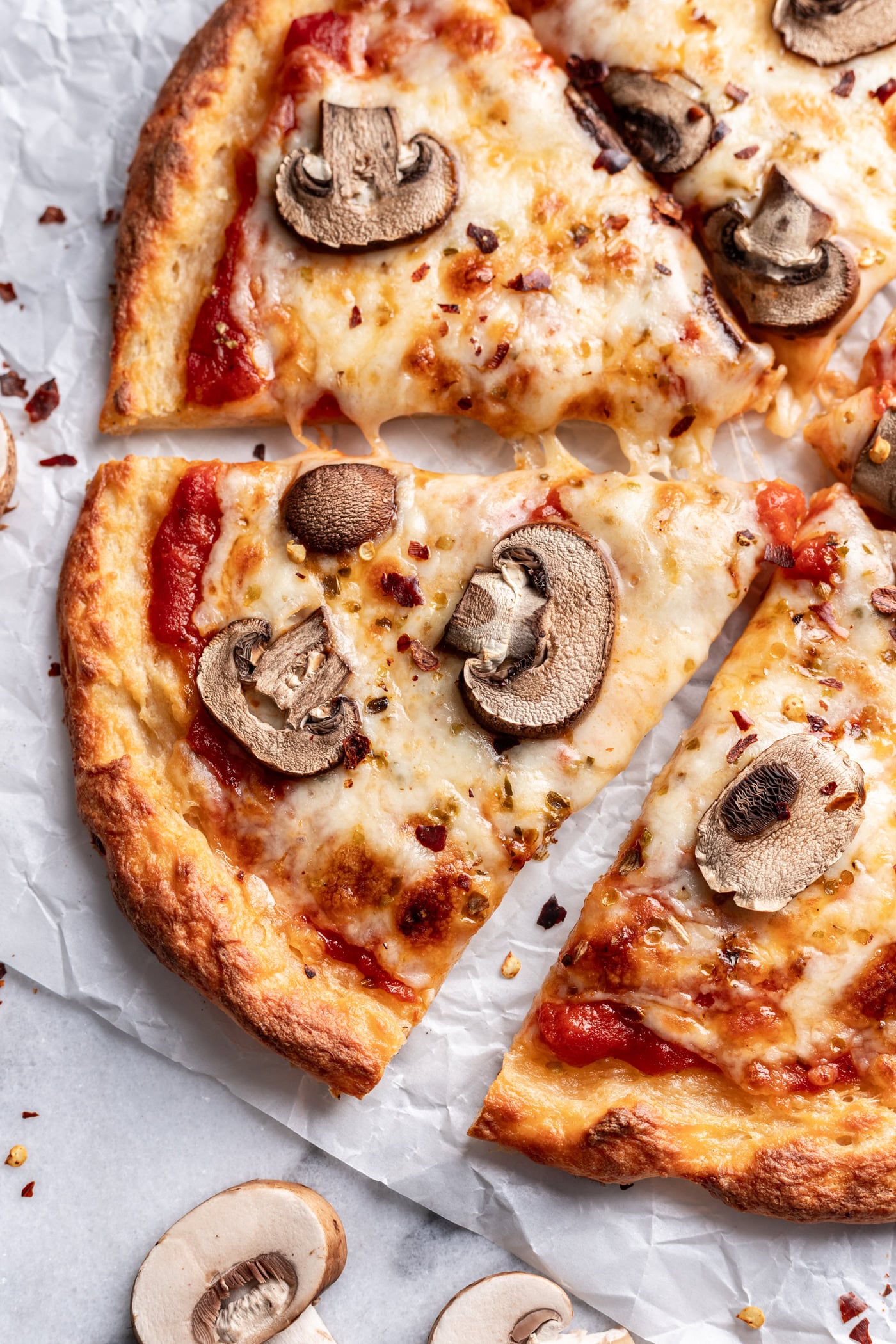 slice of cottage cheese mushroom pizza on a marble board