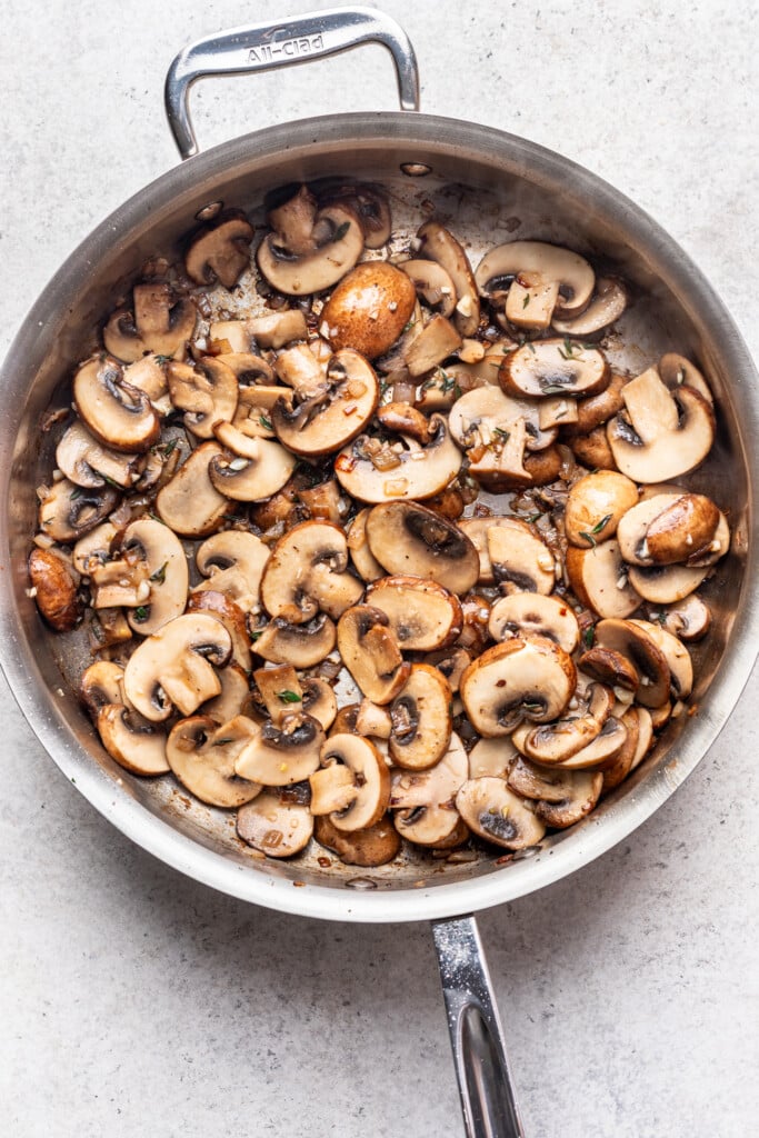 large skillet with mushrooms and zucchini