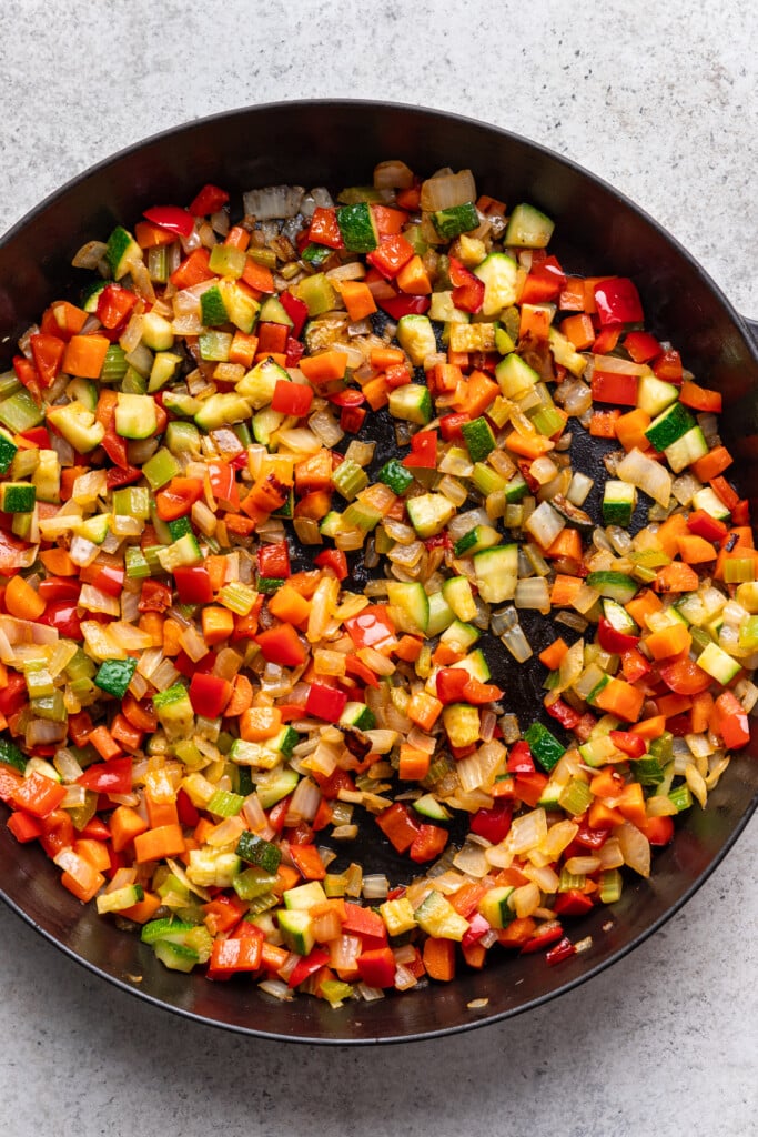 a cast iron skillet filled with chopped colorful veggies