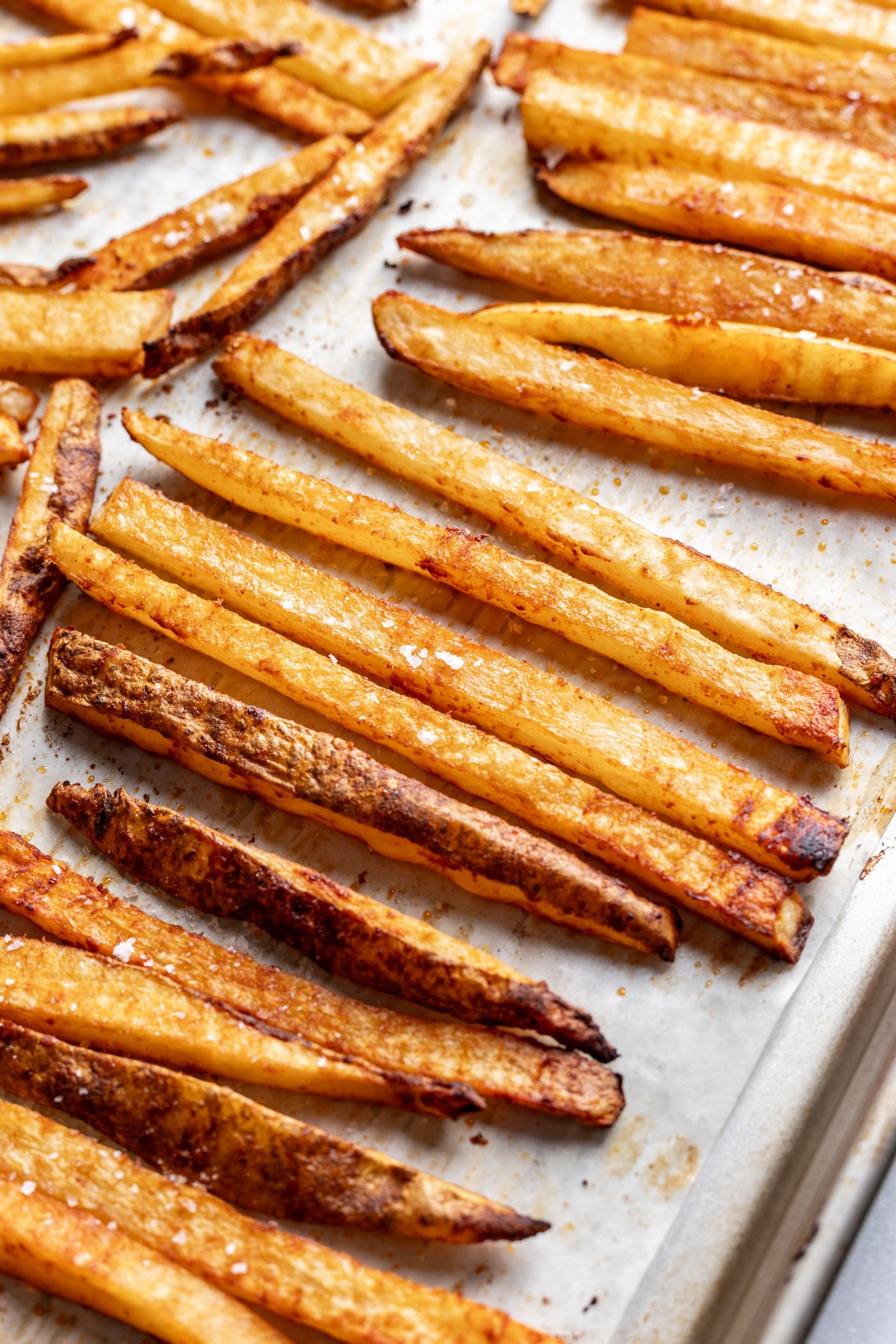 Golden crispy homemade French fries on baking sheet