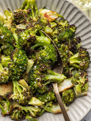 bowl of roasted broccoli with a serving spoon
