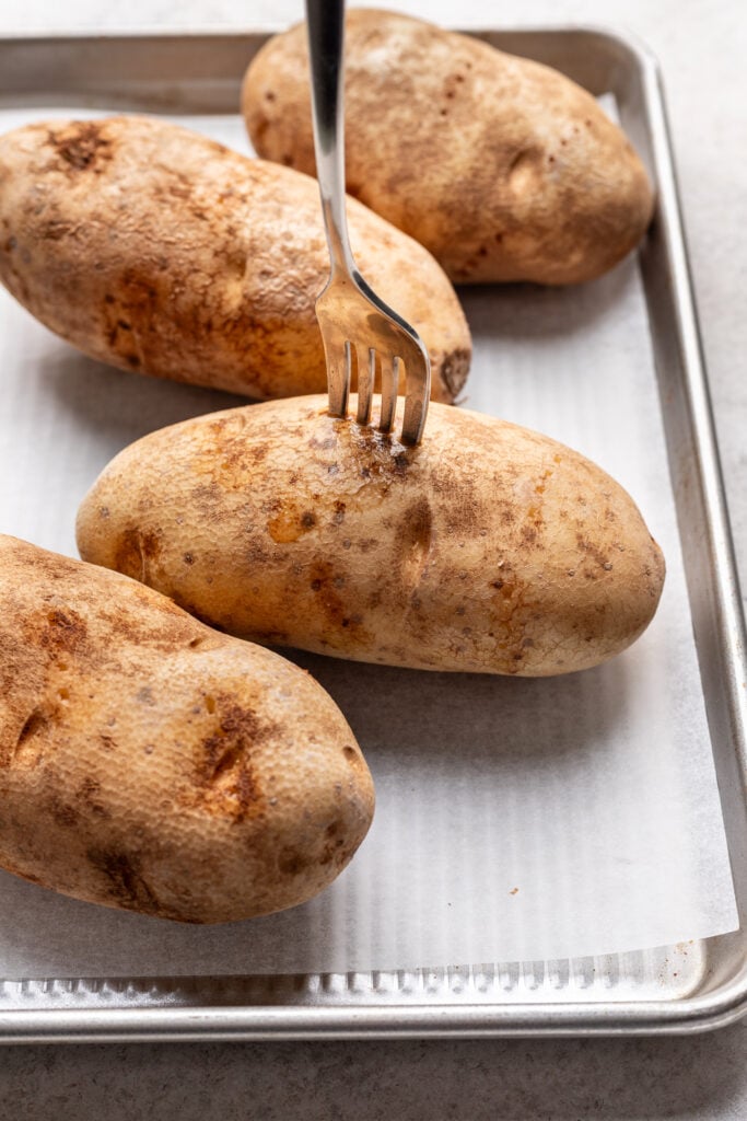 a fork poking into a russet potato