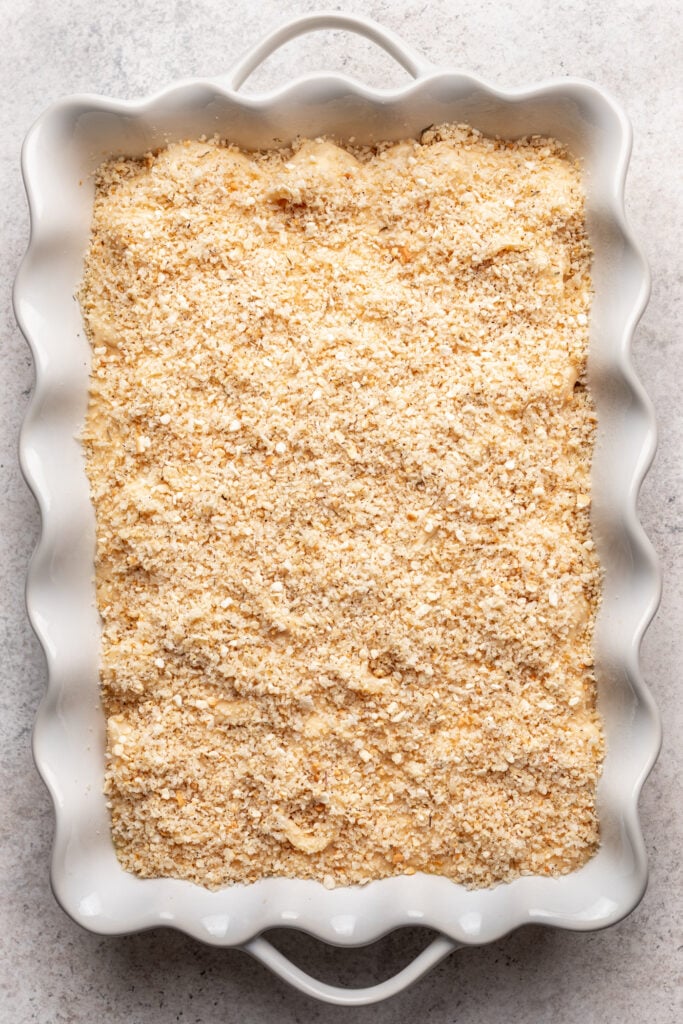 mac n cheese in a baking dish with breadcrumb topping, uncooked