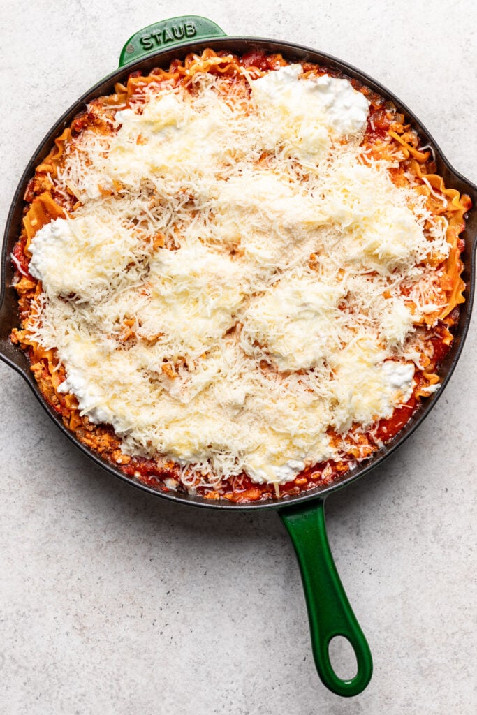 cheese on top of a skillet lasagnad