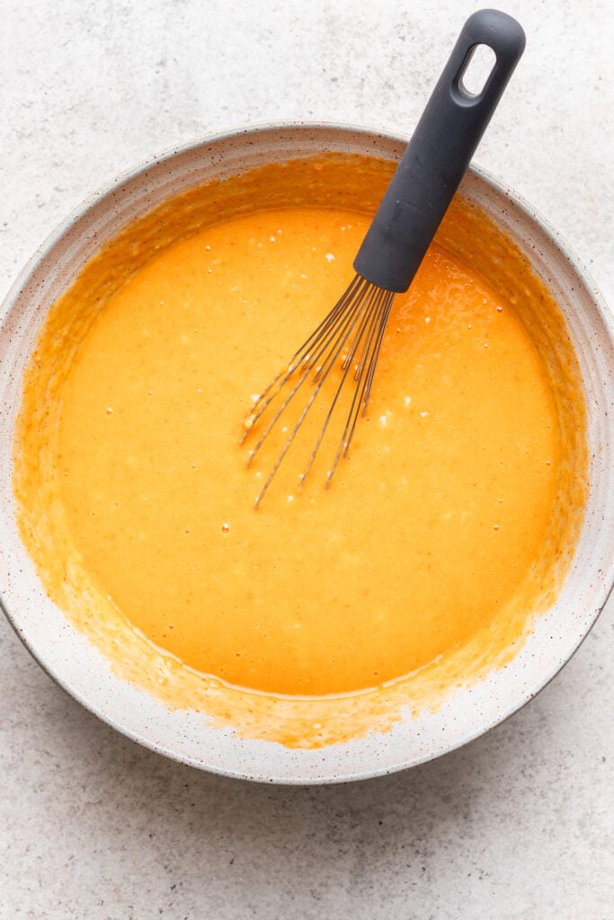 pumpkin and wet ingredients in a bowl with a whisk