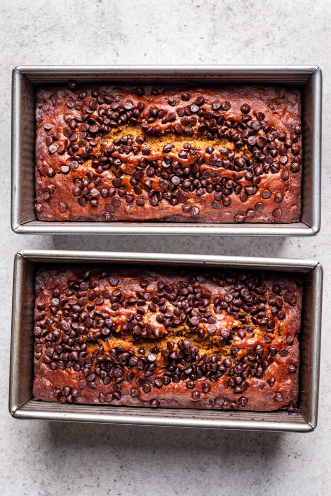 baked pumpkin banana bread loaves with chocolate chips in two rectangular pans
