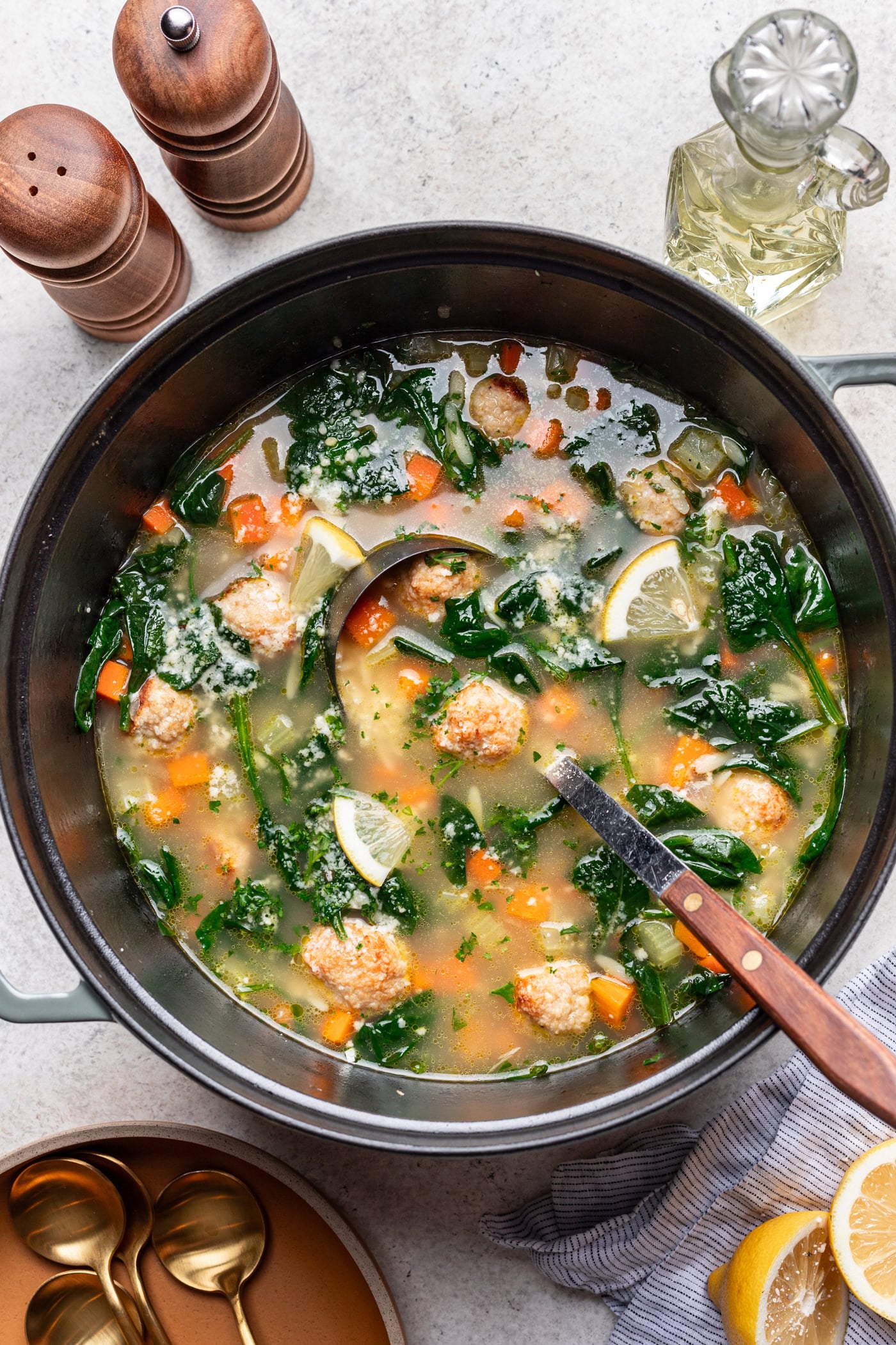 big pot of lemony chicken meatball soup with a ladle