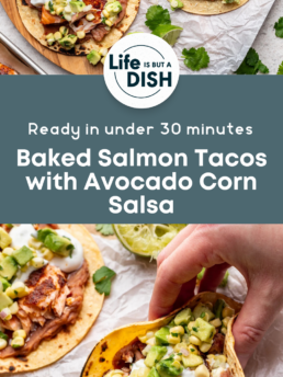 Overhead view of baked salmon tacos topped with avocado corn salsa and sour cream on tortillas, set on parchment paper. A hand holds one taco. Text reads: Baked Salmon Tacos with Avocado Corn Salsa. Ready in under 30 minutes.